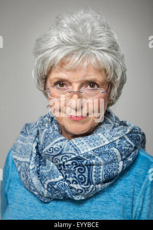 Older Caucasian woman peering over eyeglasses Stock Photo