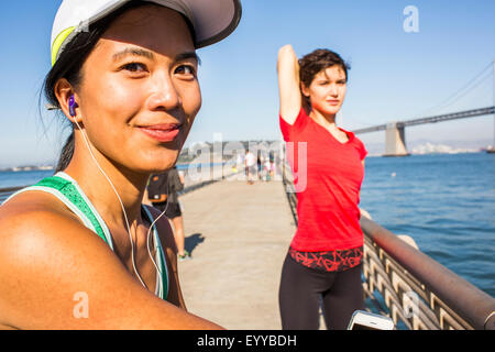 Runner stretching on urban footbridge, San Francisco, California, United States