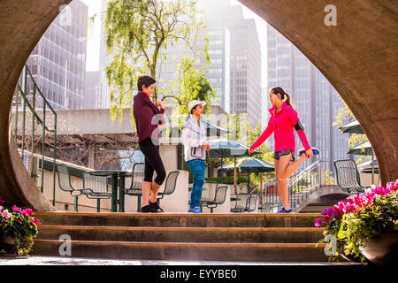 Runners stretching in urban park Stock Photo