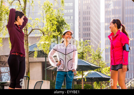 Runners stretching in urban park Stock Photo