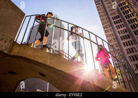 Low angle view of women running on urban staircase Stock Photo