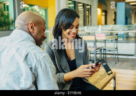 Black business people using cell phone in cafe Stock Photo