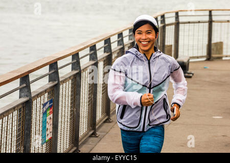 Asian woman running at waterfront Stock Photo