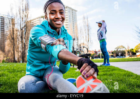 Runner stretching in urban park Stock Photo