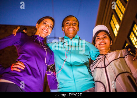 Low angle view of runners smiling at night Stock Photo