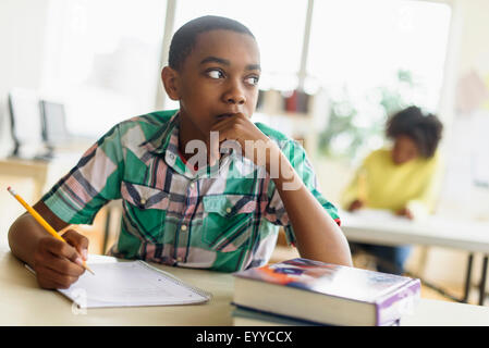 Black student thinking in classroom Stock Photo