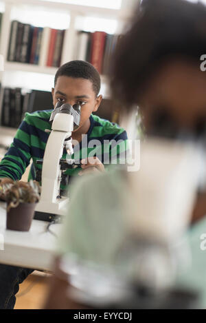 Black students using microscopes in science lab Stock Photo