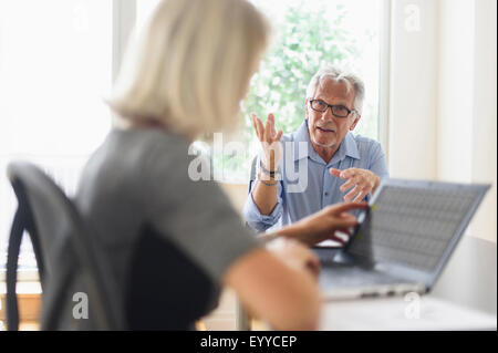 Older Caucasian business people arguing in office meeting Stock Photo
