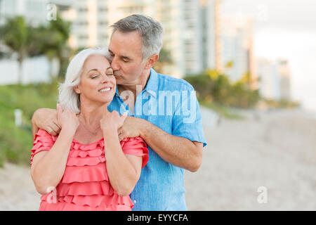 Older Caucasian couple walking on beach Stock Photo