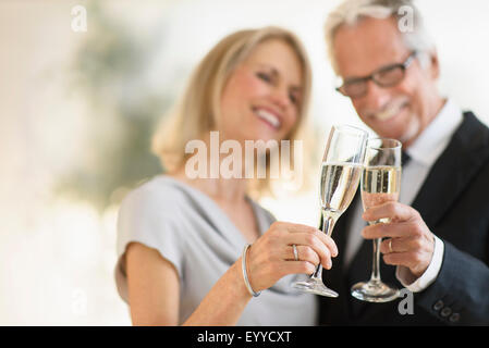 Smiling older Caucasian couple toasting with champagne Stock Photo