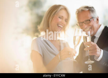 Smiling older Caucasian couple toasting with champagne Stock Photo