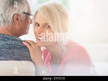 Close up of older Caucasian couple whispering Stock Photo
