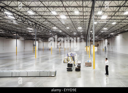 Caucasian businessman standing in empty warehouse Stock Photo