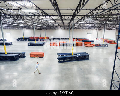 High angle view of Caucasian businessman walking in empty warehouse Stock Photo