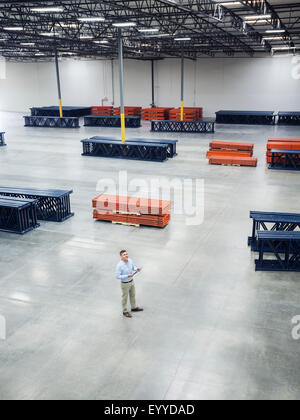 High angle view of Caucasian businessman standing in empty warehouse Stock Photo