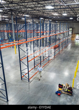 High angle view of Caucasian businessman walking in empty warehouse Stock Photo