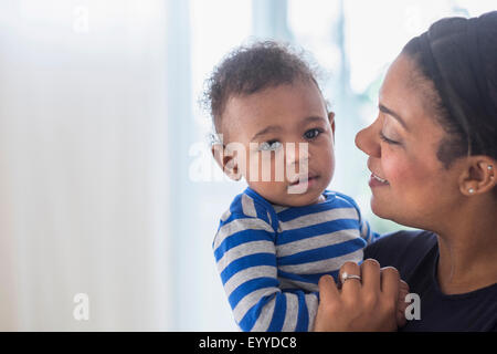 Close up of mixed race mother holding baby son Stock Photo