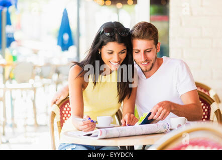 Hispanic couple reading map at cafe Stock Photo
