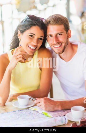 Hispanic couple reading map at cafe Stock Photo