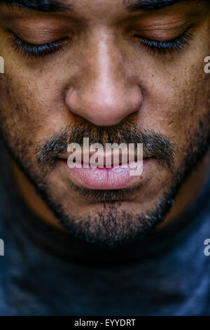 Close up of face mixed race man looking down Stock Photo