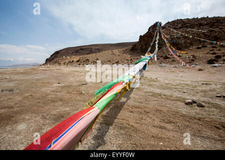 Prayer flags blowing in wind in remote field Stock Photo