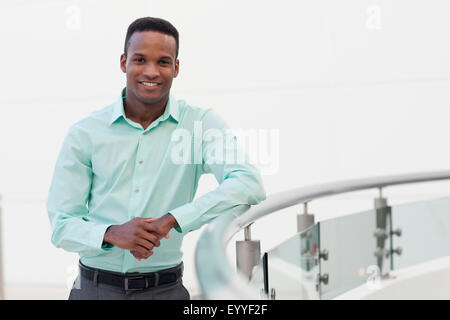 Black businessman leaning on railing Stock Photo