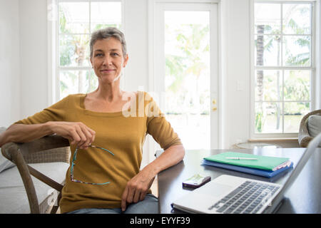 Woman using laptop in living room Stock Photo