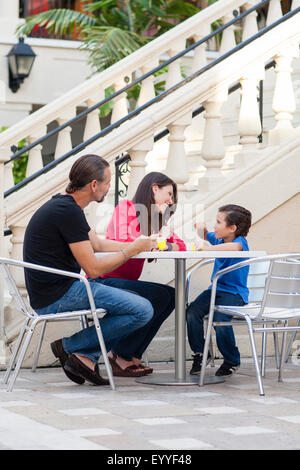Caucasian family eating at sidewalk cafe Stock Photo