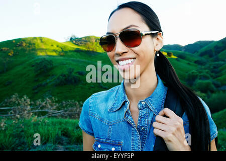 Mixed race woman smiling on rural hilltop Stock Photo