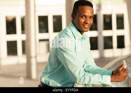 Black businessman leaning on railing Stock Photo