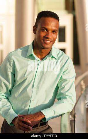 Black businessman leaning on railing Stock Photo