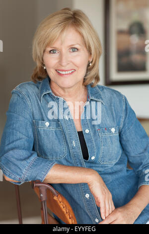 Smiling Caucasian woman sitting in chair Stock Photo