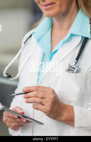 Close up of Caucasian doctor using digital tablet Stock Photo