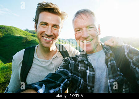 Caucasian father and son taking selfie on rural hilltop Stock Photo