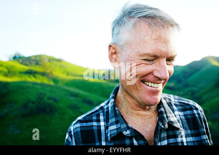 Older Caucasian man smiling on rural hilltop Stock Photo