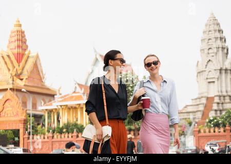 Businesswomen walking by ornate temple, Phnom Penh, Cambodia Stock Photo