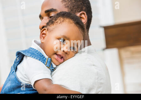 Close up of Black father holding baby son Stock Photo