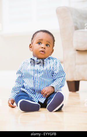 Black baby boy sitting on living room floor Stock Photo