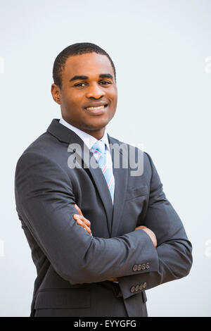 Black businessman smiling with arms crossed Stock Photo