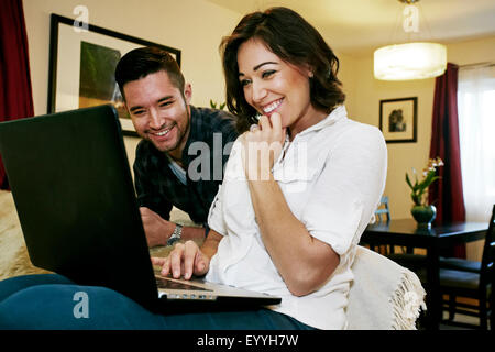 Close up of couple using laptop on sofa Stock Photo