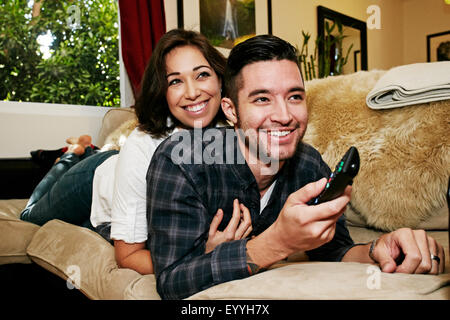 Couple watching television on sofa in living room Stock Photo