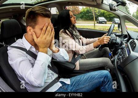 young woman driving car with a desperate co-driver, Austria Stock Photo