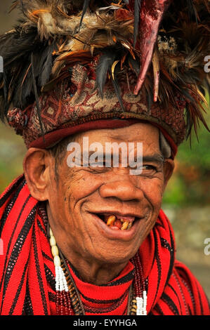 portrait of an old man with a few teeth and traditional head decoration, Philippines, Luzon, Banaue Stock Photo