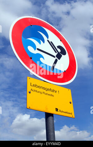 symbol warning of danger through flood wave at canalised creek, Germany Stock Photo