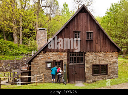 two people looking into the old ironworks and hammer mill Wendener Huette, Germany, North Rhine-Westphalia, Sauerland, Wenden-Huensborn Stock Photo