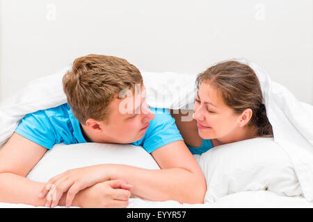 couple under blanket looking at each other Stock Photo