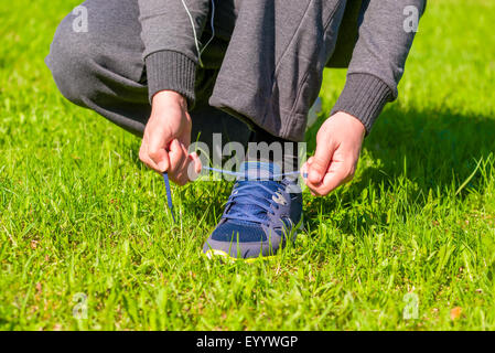 man's hands tying shoelaces from sneaker Stock Photo