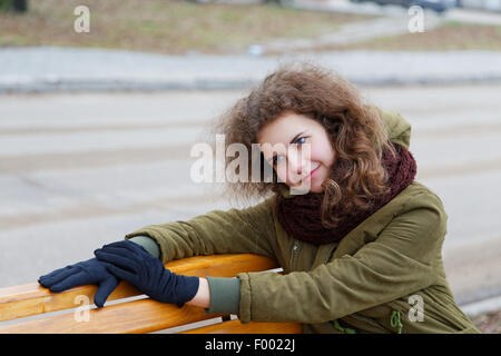 Dreaming girl on a street bench in autumn Stock Photo