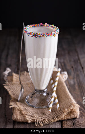 White chocolate milkshake in tall glass decorated with sprinkles Stock Photo