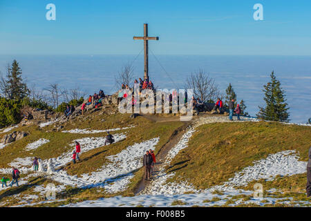 cross on the mountain summit in sunshine and mist in the valley, Germany, Bavaria, Kampenwand, Hohenaschau Stock Photo